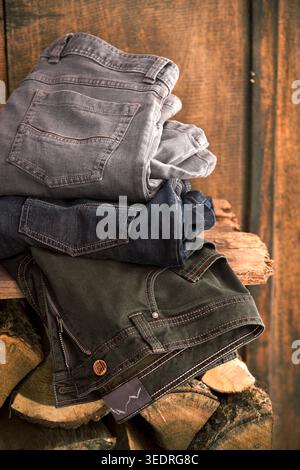 Three jeans stacked on wood Stock Photo