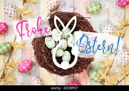 Easter bunny in an Easter nest with Easter eggs and Easter greetings, photomontage Stock Photo
