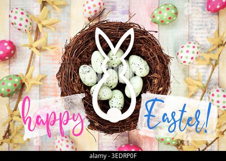 Easter bunny in Easter nest with Easter eggs and Easter greeting happy Easter, photomontage Stock Photo