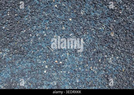 Detailed view of a granular, textured surface composed of recycled rubber granules, ideal for backgrounds and abstract designs Stock Photo