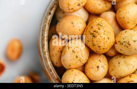 Nuts. Peanuts in glaze with seasonings and spices close-up. A delicious snack for beer.  Selective focus, top view Stock Photo