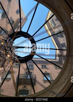 Interior view from a new roof window. Close up view of open roof window isolated with view of trees on blue sky and houses. Stock Photo