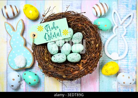 Easter bunny figurines with Easter eggs and Easter nest with label and Easter greeting, photomontage Stock Photo