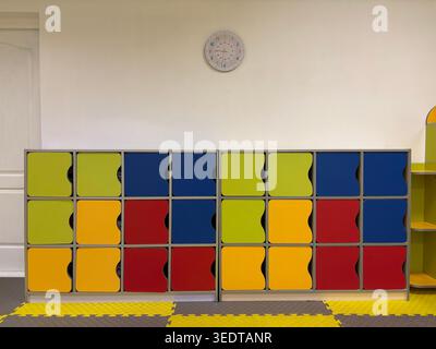Colorful storage lockers in kindergarten classroom. Bright and organized childrens space with furniture for storing personal items. Concept of education, childcare and preschool environment Stock Photo