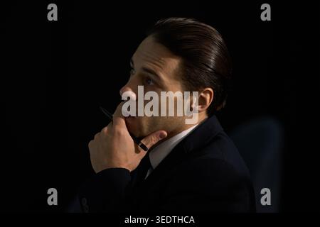 Businessman Holding Pen and Thinking during Strategic Planning Stock Photo