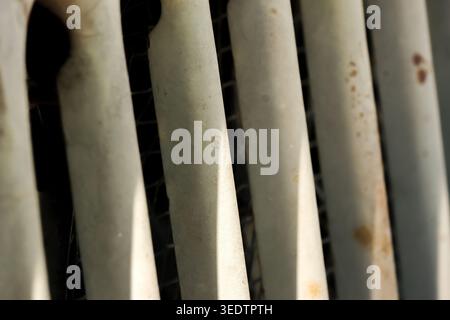 Close up macro view of old vintage rusted metal radiator heater showing textured details and parallel lines creating moody atmospheric and slightly no Stock Photo