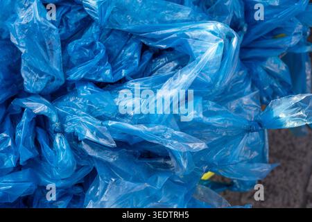 Overwhelming chaotic pile of used blue plastic glove waste representing severe environment pollution and garbage accumulation creating sad depressing Stock Photo