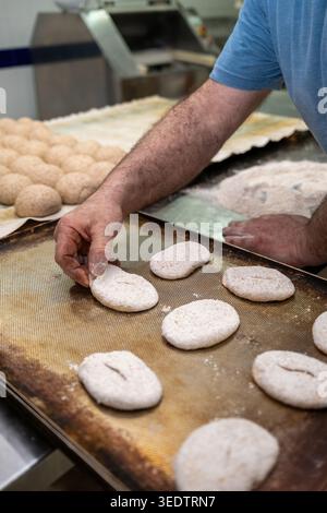 Baker preparing raw bread dough for baking Stock Photo