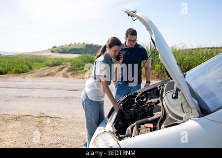 Young couple experiencing car breakdown on roadside Stock Photo