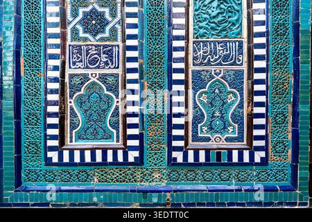 Intricate Islamic tilework with Arabic calligraphy and geometric patterns on the facade of an ancient monument in Samarkand. Traditional blue and turq Stock Photo