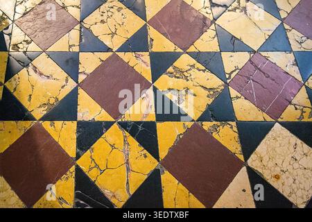 High angle view of an antique marble floor with a geometric star and diamond pattern using selective focus. The shallow depth highlights the authentic Stock Photo
