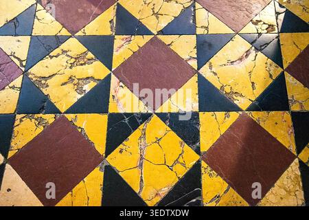 High angle view of an antique marble floor with a geometric star and diamond pattern using selective focus. The shallow depth highlights the authentic Stock Photo