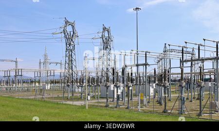 Large electric substation under blue sky with a lawn in front. Stock Photo