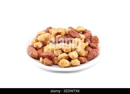 Mix of caramelized nuts: cashew,almonds and peanuts on a white plate. White background. Stock Photo