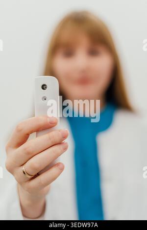 Female medical professional using portable AI powered diagnostic device representing telemedicine remote patient screening and digital healthcare Stock Photo