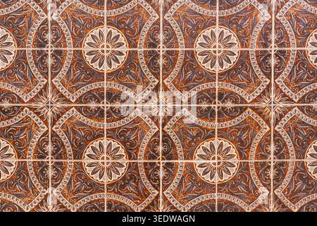 Decorative ceramic wall tiles featuring intricate brown floral and geometric motifs. Stock Photo