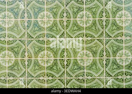 Decorative green ceramic wall tiles featuring intricate floral and geometric ornamental designs. Stock Photo