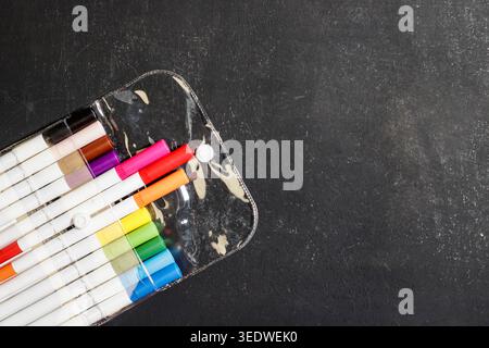Colorful markers in a clear case on a blackboard. Art and Education Supplies. Creativity Concept. Colorful pens. High quality photo Stock Photo