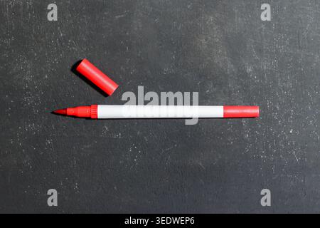 Red Marker Pen with Cap on Dark Background. Red Marker. Stationary Supplies. Learning and Education Concept. High quality photo Stock Photo