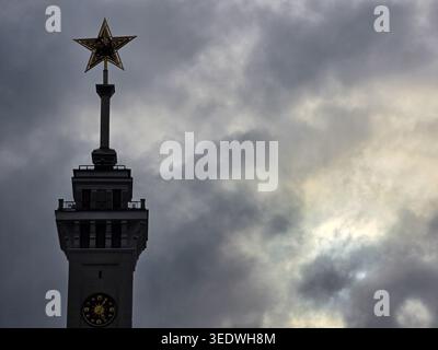 Red Soviet star against ominous gloomy dark cloudy sky, on top of tower of the north river terminal in Moscow, Russia; dark clouds; may be conceptual Stock Photo