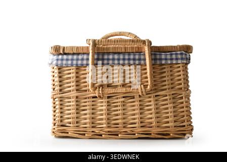 Classic wicker picnic basket with blue checkered lining isolated on a white background in a clean studio composition. Stock Photo