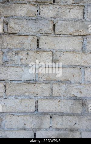 Old light brick wall texture with weathered masonry pattern background and rustic construction detail Stock Photo