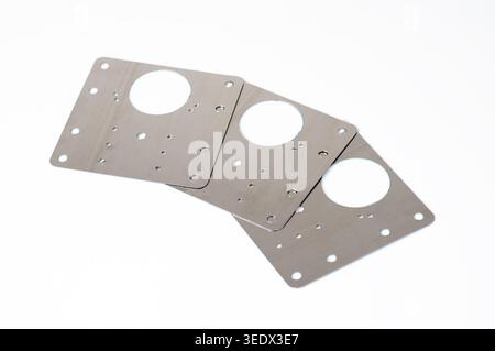 Three stainless steel cabinet hinge repair plates for fixing broken furniture doors, isolated on white background. Stock Photo