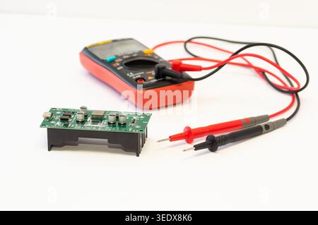 Multimeter with test probes and a circuit board Stock Photo