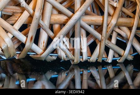 An abstract mishmash of wooden sticks reflected onto a black surface Stock Photo