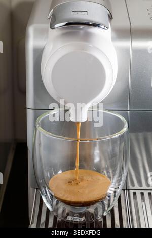 A Nespresso machine is pouring coffee from a placed cup. Stock Photo