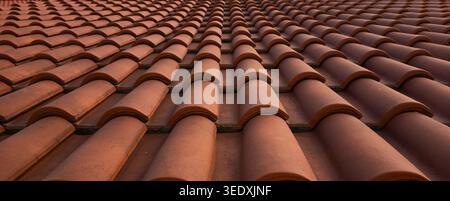 High-angle full-frame texture of new red clay roof tiles arranged in a repetitive rhythmic pattern. Stock Photo