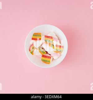 Marshmallows and gummy candies on pastel pink background. Minimal candy concept. Trendy jelly sweets aesthetic. Colorful flat lay background image. Stock Photo