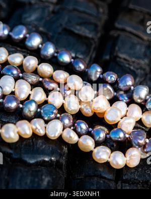 Freshwater pearl necklaces on dark textured wood background, luxury jewelry close up Stock Photo