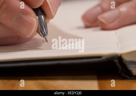 Macro Close-Up of Pen Tip Poised Above Blank Notebook Page Stock Photo