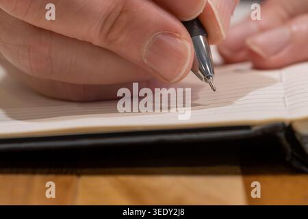 Macro Close-Up of Pen Tip Poised Above Blank Notebook Page Stock Photo