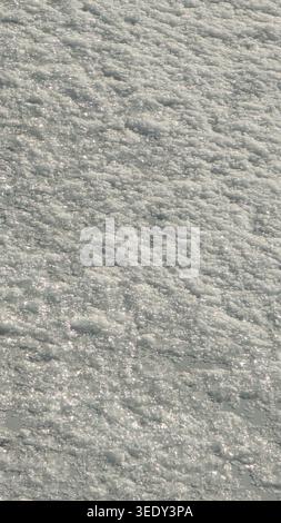 Textured surface of snow with crystalline patterns reflecting sunlight background with copy space. Stock Photo