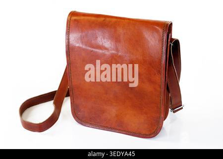 Brown leather satchel shoulder bag with a long strap, styled with a vintage look and isolated on a white background Stock Photo
