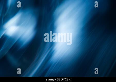 Abstract blurred blue light rays reflecting diagonally on a dark background Stock Photo
