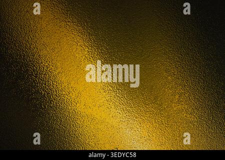 Dark gold and black frosted glass texture with diagonal light beam Stock Photo