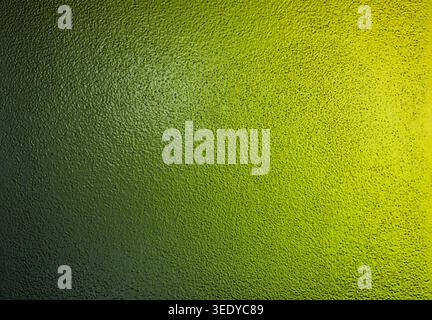 Lime green and vibrant yellow gradient light on a rough textured glass panel Stock Photo