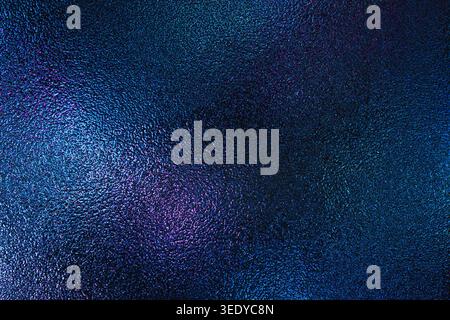 Iridescent blue and purple light reflecting on a bumpy glass texture Stock Photo