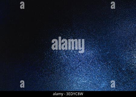 Deep metallic navy blue gradient reflecting on a textured opaque glass material Stock Photo