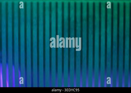 Vibrant gradient of teal green and purple light on a vertical ribbed glass texture Stock Photo
