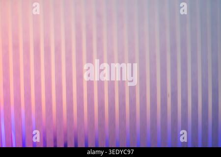 Soft pastel pink and purple gradient illuminating a vertical striped glass texture Stock Photo
