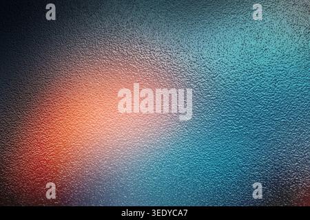 Abstract textured glass surface with vibrant orange and blue gradient lighting Stock Photo