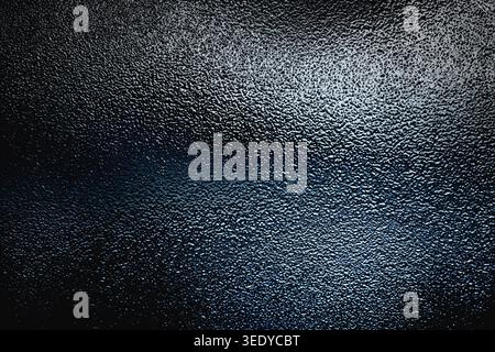 Dark grey and blue frosted glass texture with high contrast lighting and rough surface Stock Photo