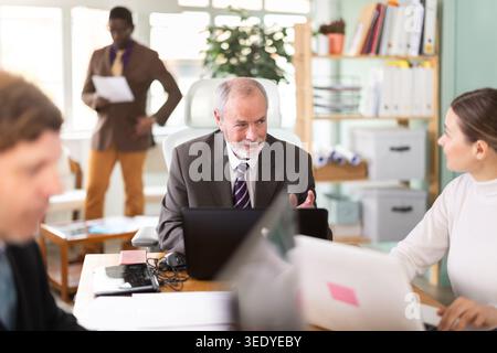 Mature man working in a team in an office Stock Photo