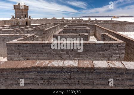 Intricate maze of stacked salt brick labyrinth walls and an ornate tower rising from the Salar de Uyuni salt flat near Colchani, Potosi, Bolivia Stock Photo