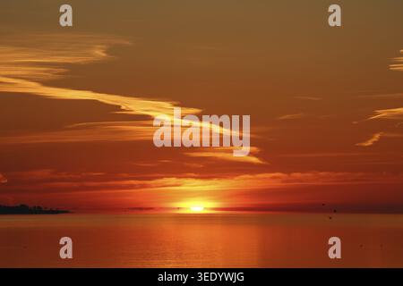 Intense sunset with glowing sky over the sea, Eckernfoerde Bay Stock Photo