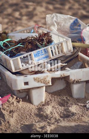 Littered trash at sand beach. Stock Photo